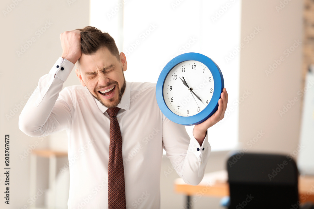 Businessman with clock in office. Time management concept Businessman with clock in office. Time management concept