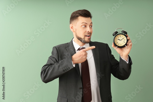 Businessman with alarm cloc...