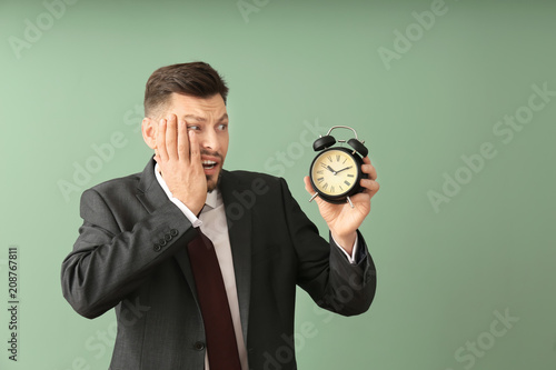 Businessman with alarm cloc...