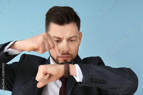 Man looking at wristwatch o...