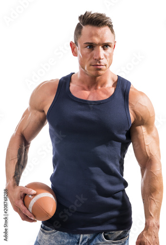 Muscular man holding football or rugby ball, isolated on white background in studio