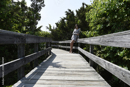 Young woman walking on boardwalk photo