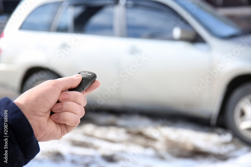 Young woman using car alarm outdoors
