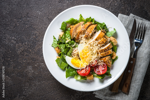 Caesar salad with chicken breast and tomatoes.
