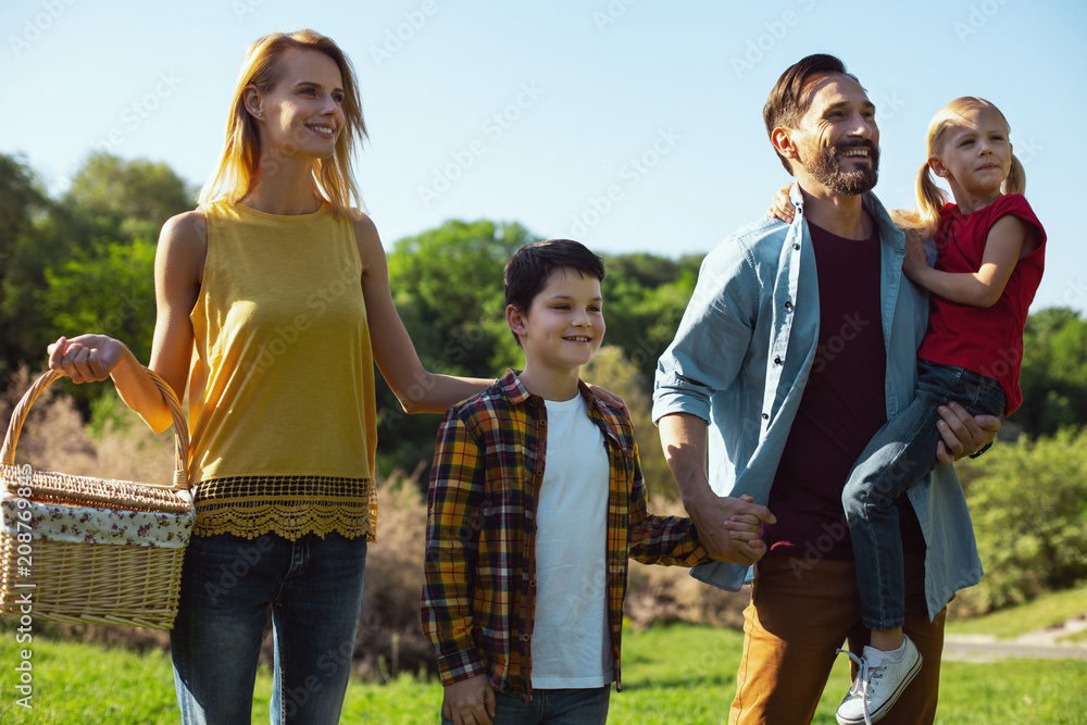 Our precious. Delighted dark-haired man holding his daughter while spending time with his family Our precious. Delighted dark-haired man holding his daughter while spending time with his family