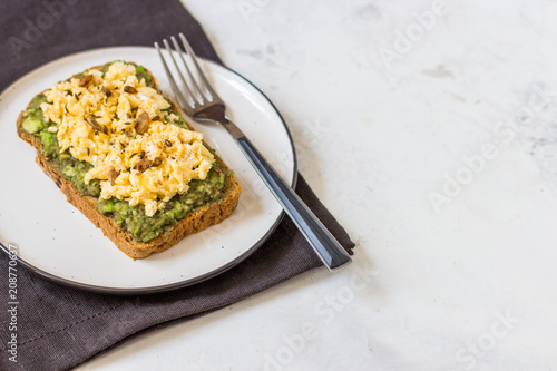 Scrambled eggs on whole wheat bread with avocado