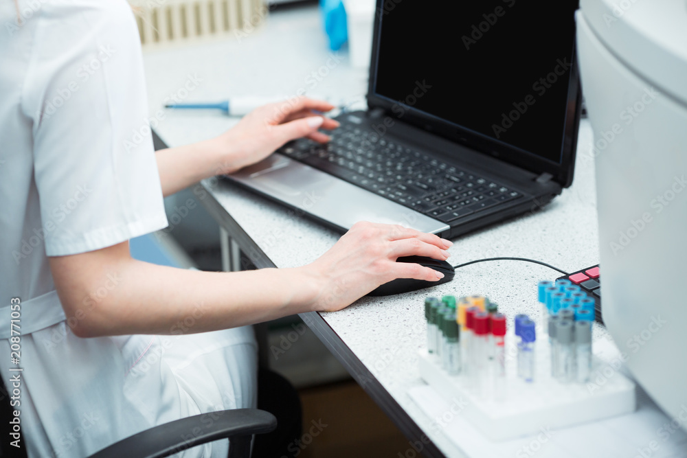 Modern technology in science. Scientist entering data of analysis or research results to laptop at laboratory. Modern technology in science. Scientist entering data of analysis or research results to laptop at laboratory.