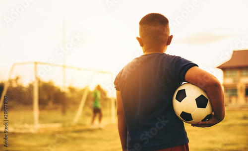 An action sport picture of a group of kid playing soccer football for exercise in before the sunset. Picture with copy space for world cup concept. © nateejindakum