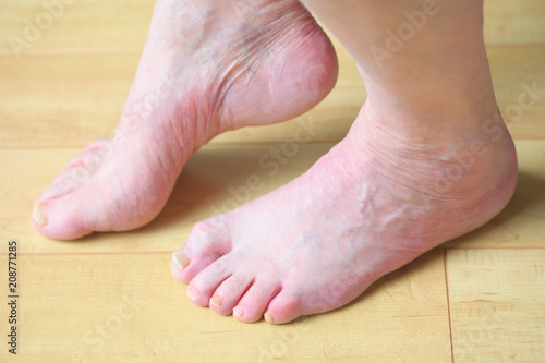 A man slightly raises one bare foot on the floor