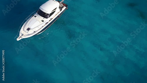 Amazing spiral shot of boat at crystal clear sea.