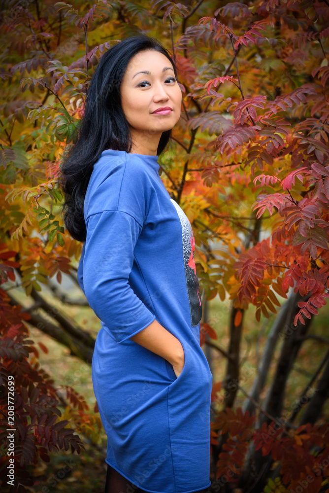 Fall woman smiling - Autumn portrait of happy lovely and beautiful mixed race Asian Caucasian young woman in forest in fall colors. Fall woman smiling - Autumn portrait of happy lovely and beautiful mixed race Asian Caucasian young woman in forest in fall colors.