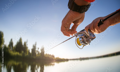 Fishing background. Fisherman with spinning on the lake.