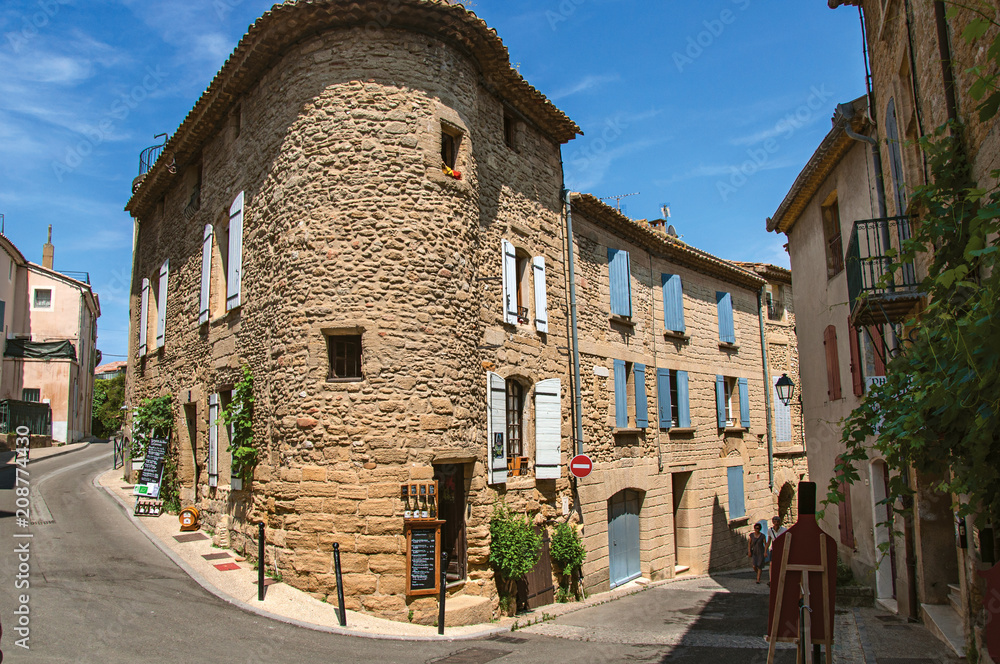 Street view with stone houses in the center of the village of Chateauneuf-du-Pape, blue sky and sunny day. Located in the Vaucluse department, Provence-Alpes-Côte d'Azur region in southeastern France