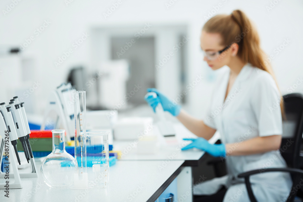 Pipette dropping a sample in a test tube. Laboratory assistant analyzing blood in lab. Aids, hiv test Pipette dropping a sample in a test tube. Laboratory assistant analyzing blood in lab. Aids, hiv test