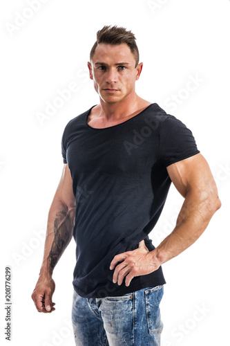 Handsome athletic muscle man in black t-shirt isolated on white, looking at camera