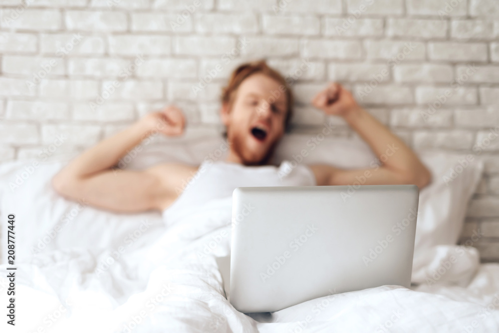 Red haired young businessman stretches in bed Red haired young businessman stretches in bed