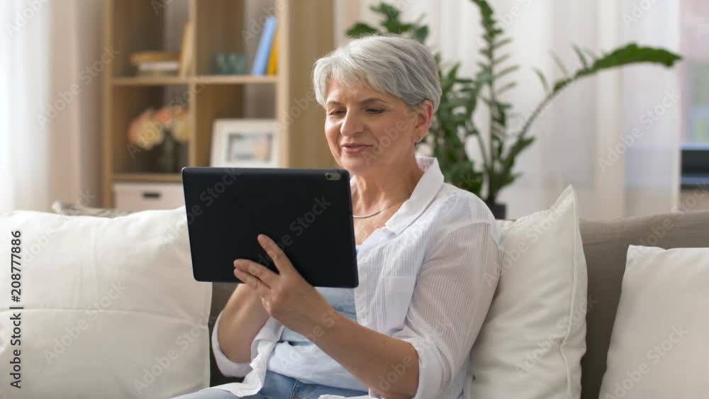 technology, people and communication concept - happy senior woman with tablet pc computer having video chat at home technology, people and communication concept - happy senior woman with tablet pc computer having video chat at home