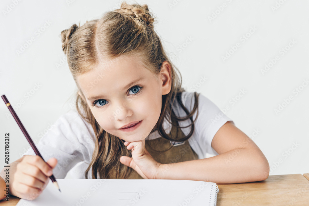 beautiful little schoolgirl drawing and looking at camera isolated on white beautiful little schoolgirl drawing and looking at camera isolated on white