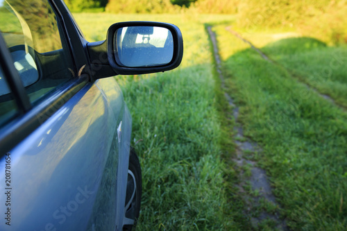 Close-up view of car on green grass nature background. Outdoors trip on car. © dzmitrock87