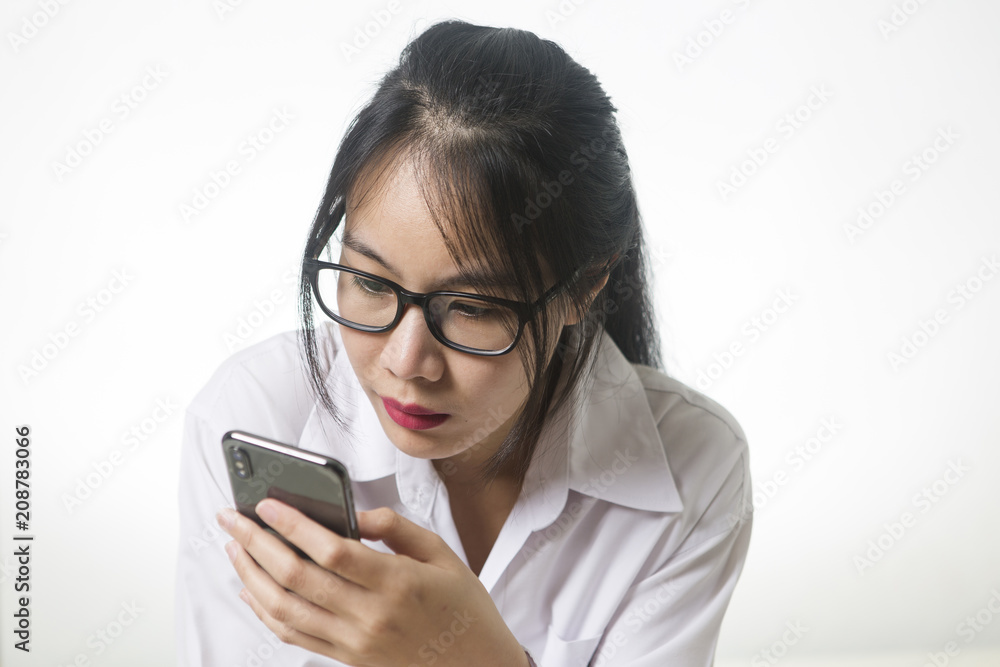 Portrait of attractive young woman wearing glasses while using cellphone or smartphone.