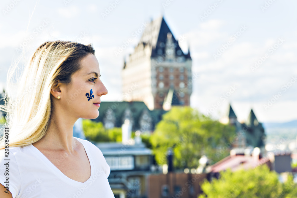 Obraz premium Woman celebrates the national holiday in front of Chateau Frontenac in quebec city