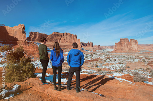 Three friends enjoying the view, visiting the Arches National Park, Utah, USA.