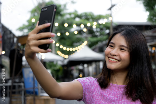Wallpaper Mural Happy woman selfie with smartphone. Portrait young Asian girl happy smile self-photography. Technology lifestyle concept Torontodigital.ca
