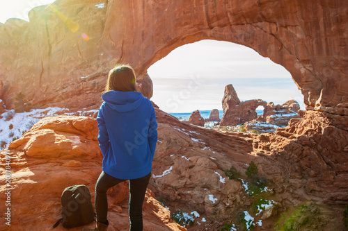 Young woman traveler enjoying the natural beauty of the Double Arch rock formation in Arches National Park. photo