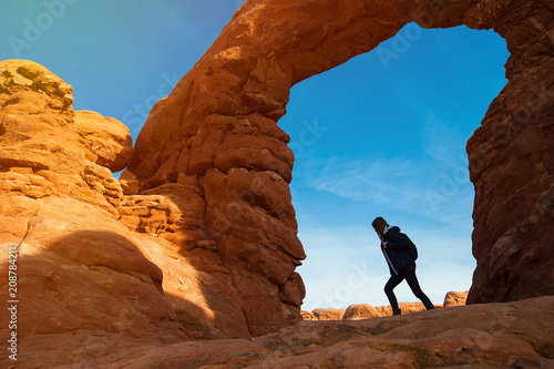 Young woman traveler with backpack hiking the Turret Arch, Arches National Park in Utah