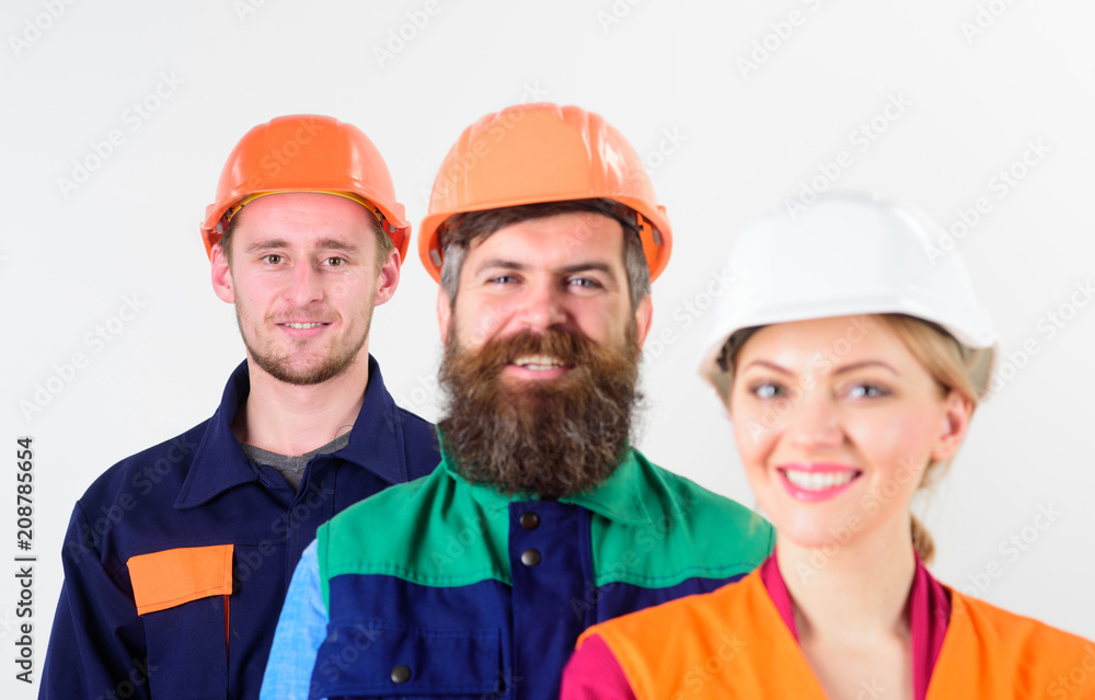 Woman and men in hard hat stand close as team. Woman and men in hard hat stand close as team.