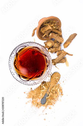 Dried Indian sarsaparilla or Hemidesmus indicus or nannari or annatmol with its syrup and powder used in mant Indian & Asian beverages isolated on white. photo