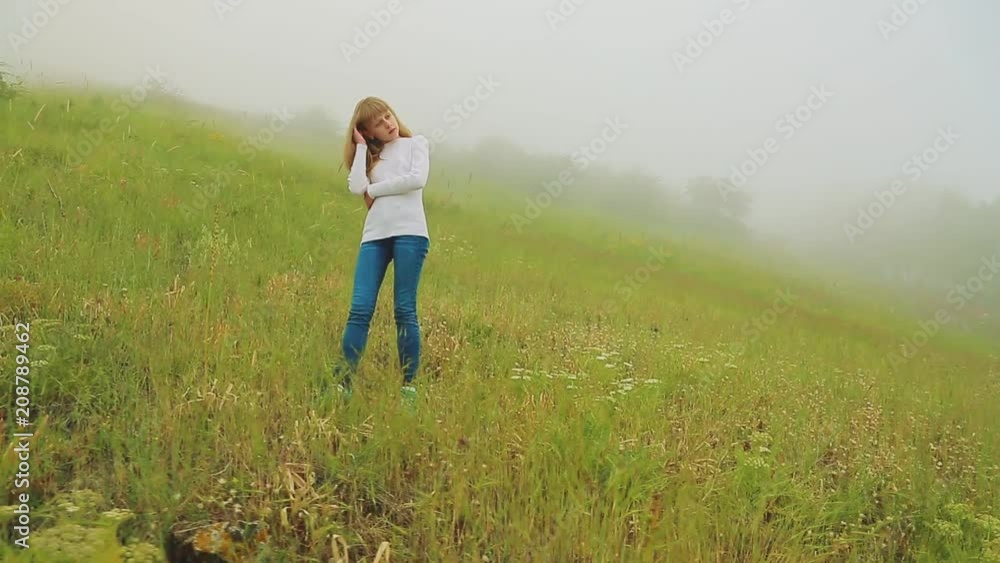 The girl climbs the barren mountain in the fog. The girl climbs the barren mountain in the fog.