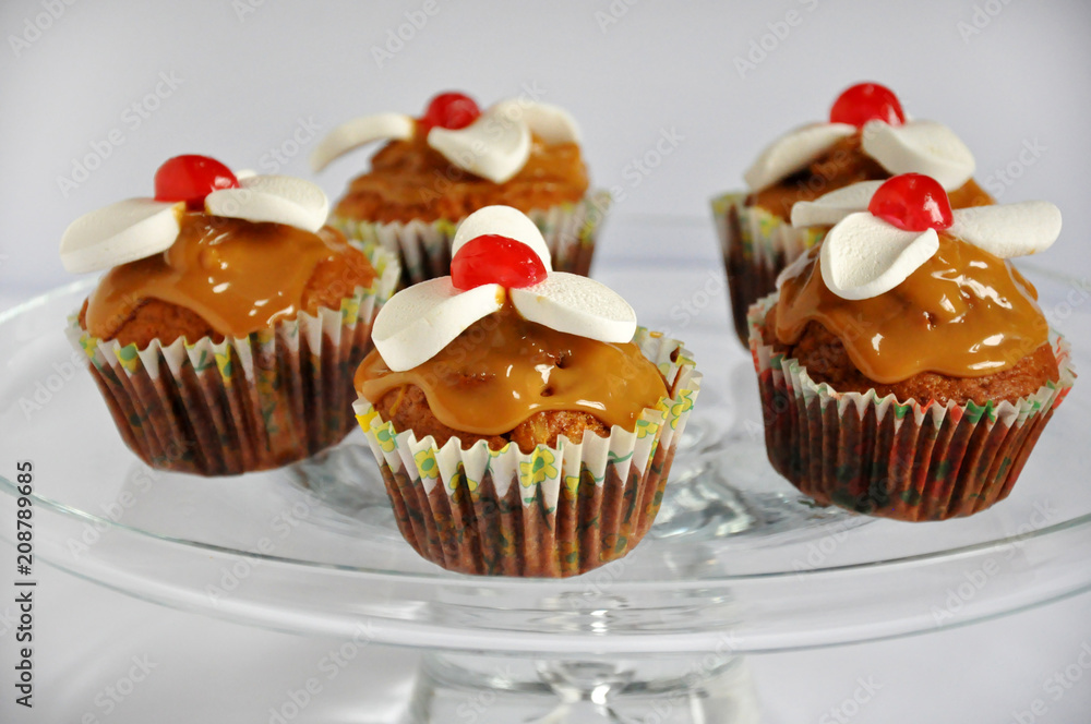 Muffins with caramel and sweet foam on a light background