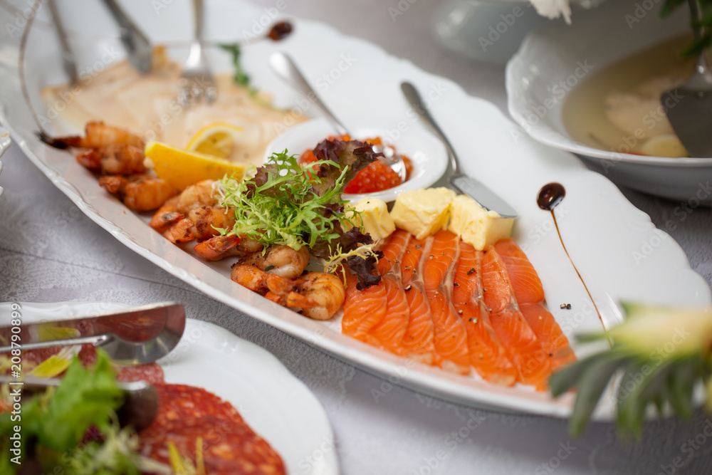 Buffet table of reception with cold snacks, shrimp, fish, caviar
