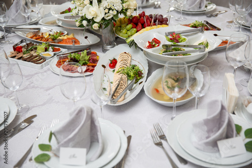 Buffet table of reception with cold snacks, meat, salads and fruits