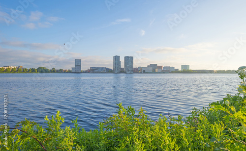 Skyline of a city along the shore of a lake at sunrise in spring