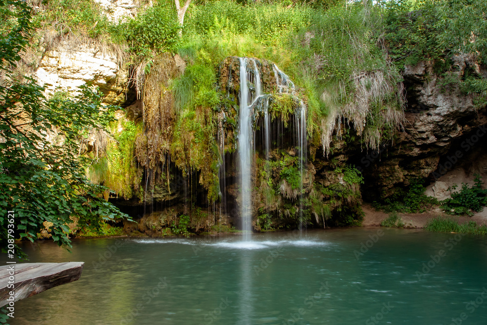 Obraz premium Waterfall and a beautiful lagoon lake for relaxing in the summer forest.
