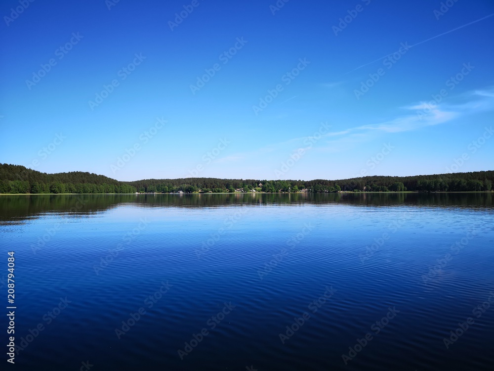Mirror forest panorama over a clear lake