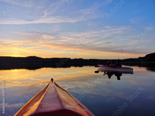 Observing a sunset over a lake from a kayak © Mantas