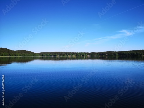 Mirror forest panorama over a clear lake