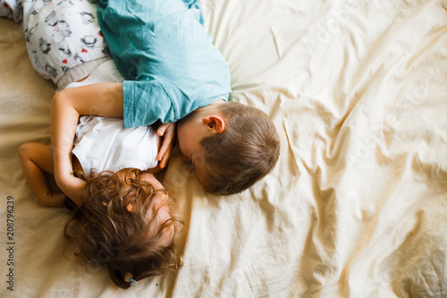 Children in soft warm pajamas playing in bed. photo