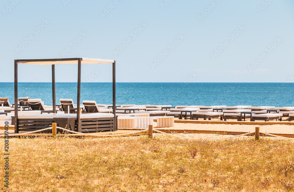 beautiful and comfortable sun loungers by the sea on an Algarve beach beautiful and comfortable sun loungers by the sea on an Algarve beach