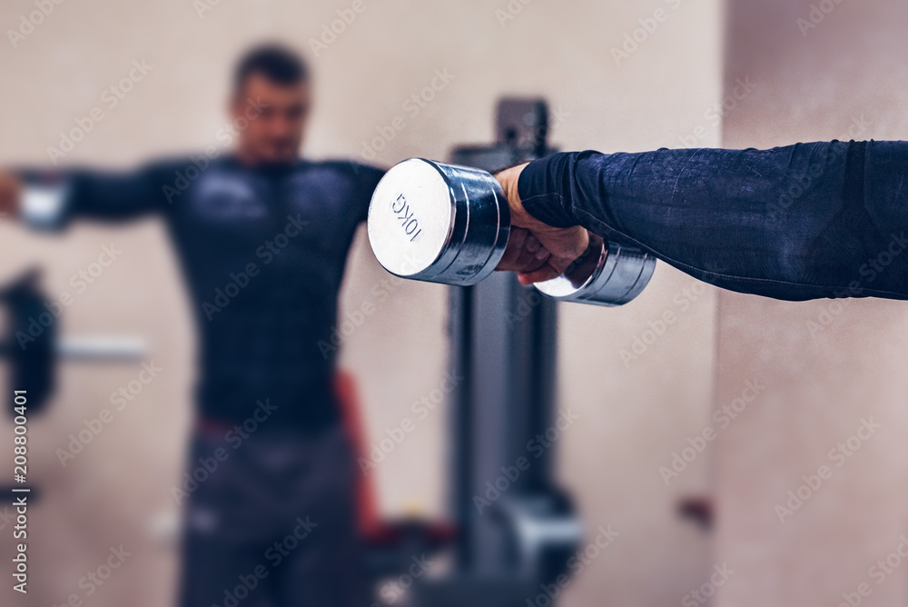 Young athlete works out in gym blurred
