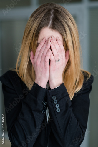 Wallpaper Mural emotion concept. sad distraught woman covering her face with hands. crying business lady in office workspace. bad news Torontodigital.ca