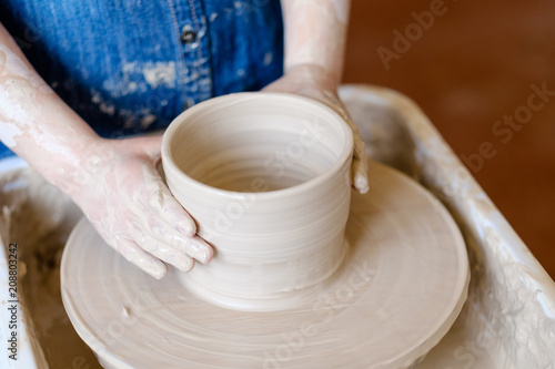 pottery art therapy. creative relaxing leisure. little child hands shaping a clay jug