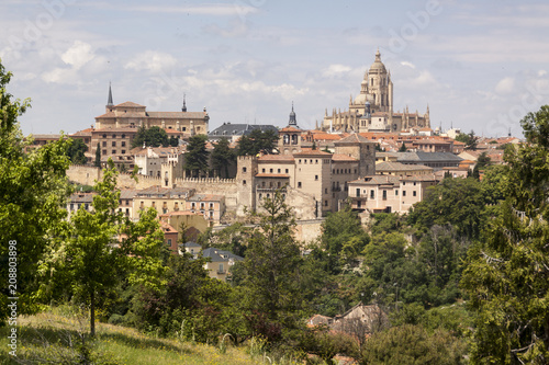 Photograph of monumental Segovia. Cathedral, aqueduct and historical center. Trees and plants in the spring season. Segovia, Castilla y Leon. Spain, Europe. 