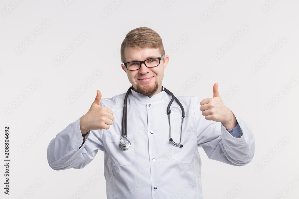 Portrait of handsome male doctor showing thumbs up over white background Portrait of handsome male doctor showing thumbs up over white background