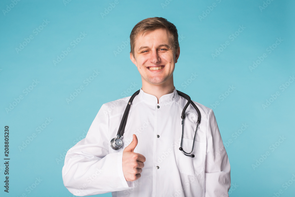 Medical physician doctor man showing thumbs up over blue background Medical physician doctor man showing thumbs up over blue background