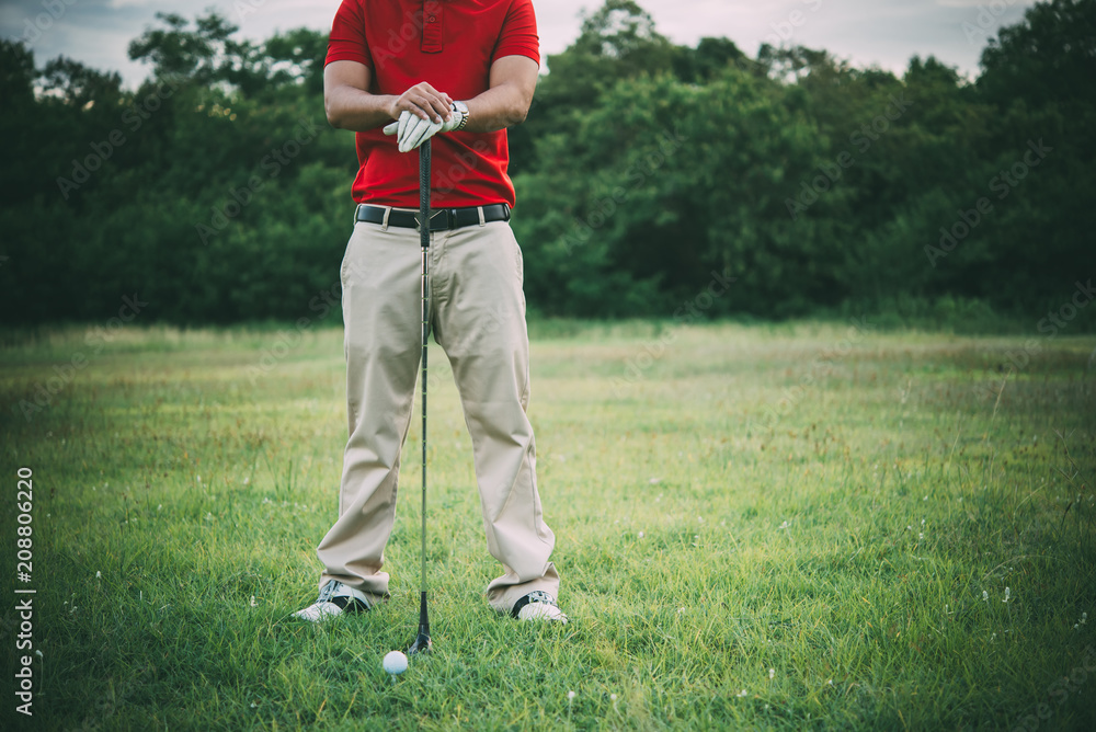 Obraz premium Golf club and ball on grass,Golfer play golf in a country club,Thailand people,The golf training before the competition.