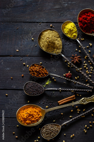 Indian spices selection over dark wooden table. Food or spicy cooking concept, Healthy eating Background.